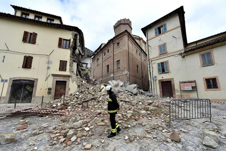 A firefighter stands in front of the collapsed bell tower of the Santa Maria in Via church in the 'red zone', an area cordoned off for safety reasons, in Camerino, where 80 per cent of the houses have been left uninhabitable after two earthquakes hit the region. (28 October, 2016) ALBERTO PIZZOLI/AFP/Getty Images