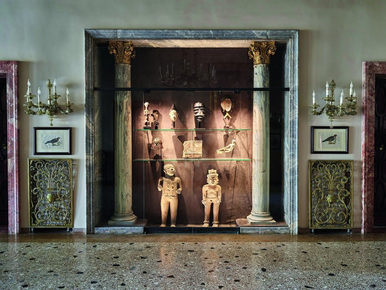 Vitrine containing 19th/20th-century sculptures from Africa, a Corinthian helmut and reclining figure from Magna Graecia, both 5th century BC, and a relief from Saqqara; below: two Veracruz terracotta figures from Mexico, Photo: James Mollison; © Giancarlo Ligabue Foundation