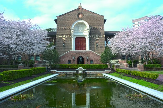 The main Kamin entrance and the Warden Garden of the Penn Museum. In front of the entrance stands a reproduction from 1903 of the Borghese Satyr