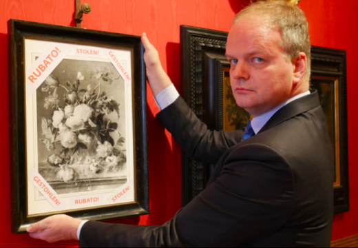 Uffizi director Eike Schmidt with a framed photograph of 'Vase of Flowers' and the word 'stolen' in Italian, English and German. Photo: @UffiziGalleries via Twitter