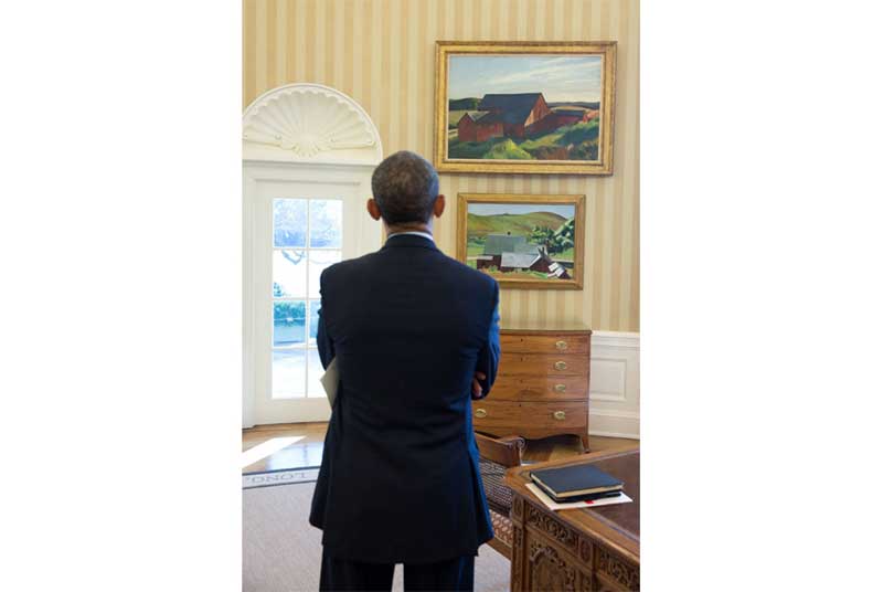 President Barack Obama looks at the Edward Hopper paintings now displayed in the Oval Office, February 7, 2014. The paintings are Cobb's Barns, South Truro, top, and Burly Cobb’s House, South Truro