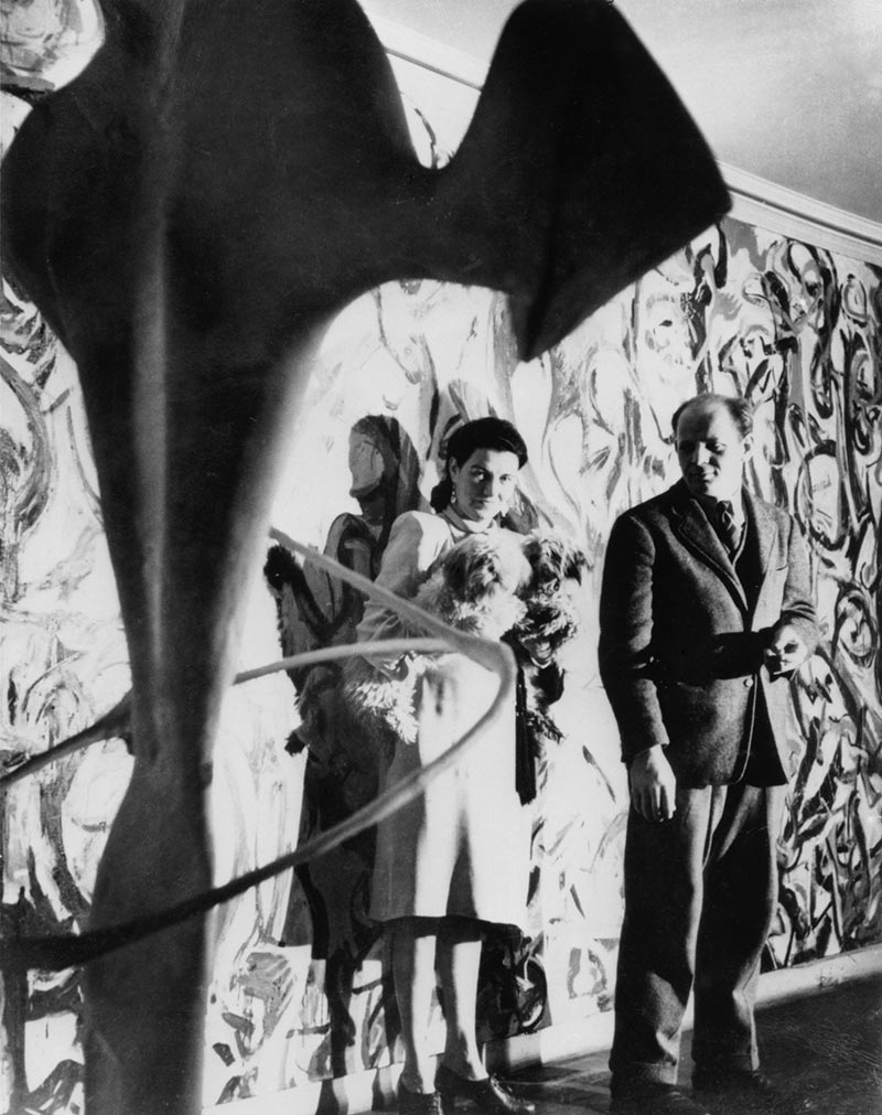 Peggy Guggenheim and Jackson Pollock in front of Pollock's Mural (1943) in the first-floor entrance hall of Guggenheim's residence, 155 East 61st Street, New York, c. 1946. Other work shown: unidentified David Hare sculpture (partially visible, foreground; c. 1946)