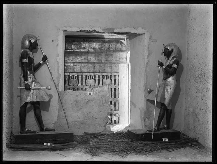 Two ‘guardian’ statues standing on either side of the entrance to the Burial Chamber. Photo by Harry Burton, 1922 © Griffith Institute, University of Oxford