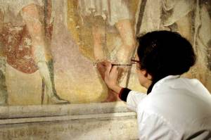 A restorer working on damaged frescos in the crypt of Sant'Eustorgio church at Milan, Italy.