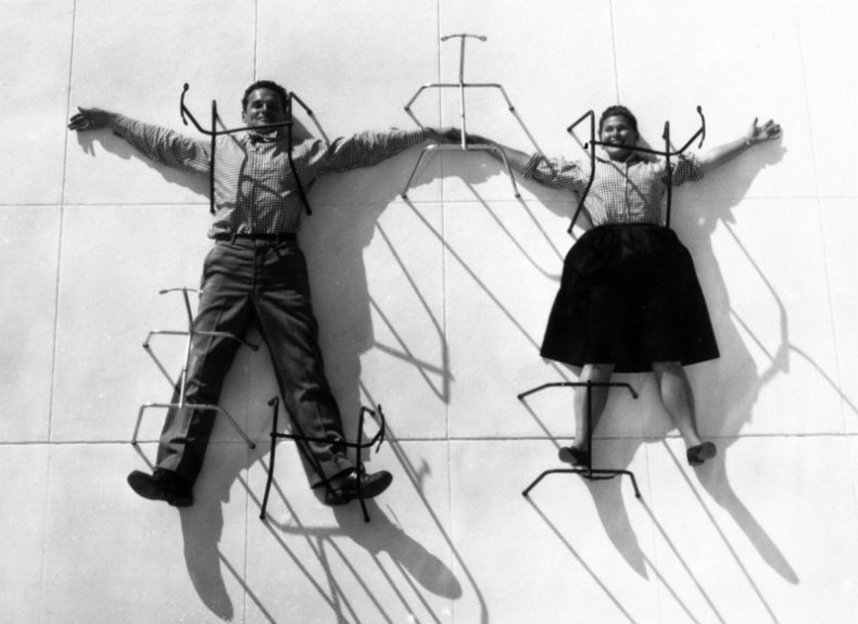 Charles and Ray Eames posing with chair bases
