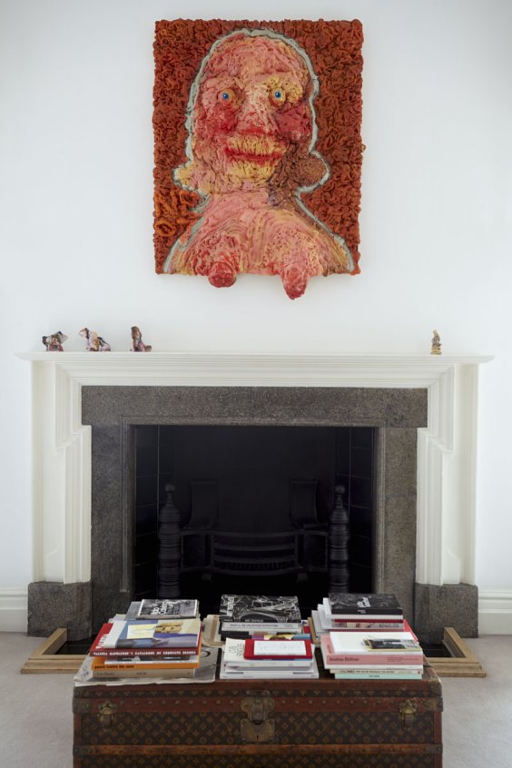 Saggy Titties (2007) by Nicole Eisenman hangs above a fireplace