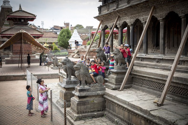 Children play on the stone lions at the base of the Khrishna Mandir, which was shored up after the 2015 earthquake and awaits restoration by the KVPT. Photo: Scott Newman
