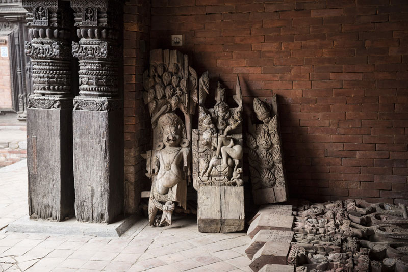 Architectural fragments rescued from the debris of a fallen temple in Patan Darbar Square are sheltered in a palace courtyard, now part of the Patan Museum, awaiting conservation and reuse. May 2015. Photo: Scott Newman