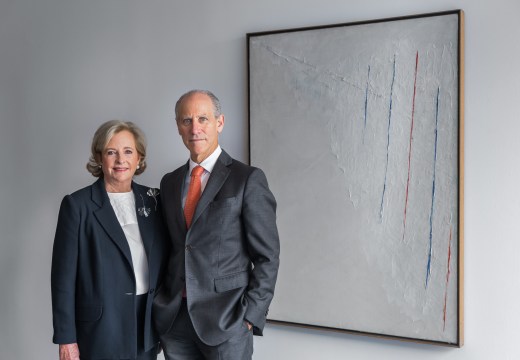 Patricia Phelps de Cisneros and Glenn D. Lowry, Director, The Museum of Modern Art, stand next to Alejandro Otero, 'Colored Lines on White Background' (1950) © 2016 Scott Rudd