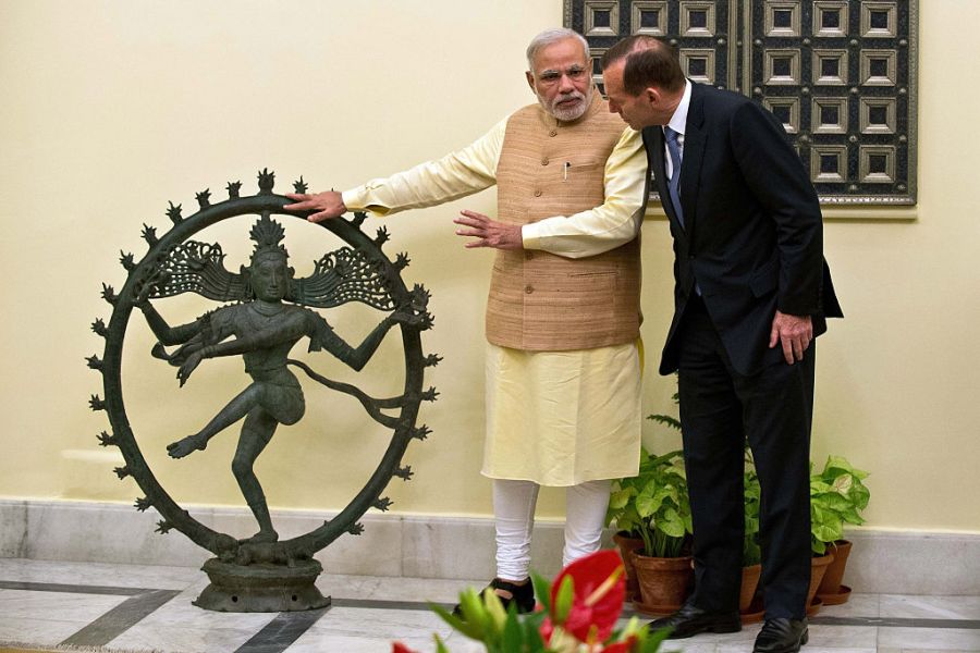 Indian Prime Minister Narendra Modi and Australian Prime Minister Tony Abbott talk alongside a statue of the Dancing Shiva ahead of a meeting in New Delhi, 5 September, 2014. The $5 million bronze statue was returned to India from the National Gallery of Australia after it emerged that it had been stolen from a Tamil Nadu temple. PRAKASH SINGH/AFP/Getty Images)