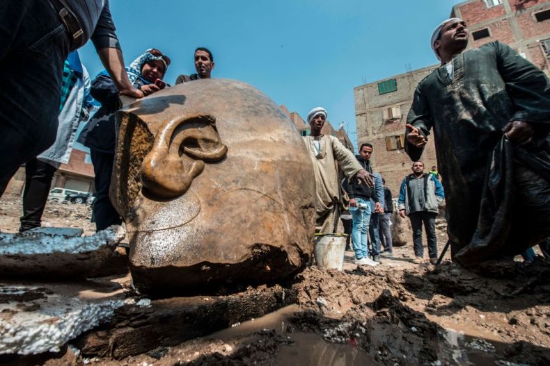 Egyptian workers look at the site of a new discovery by a team of German-Egyptian archeologists in Cairo's Mattarya district on March 9, 2017.