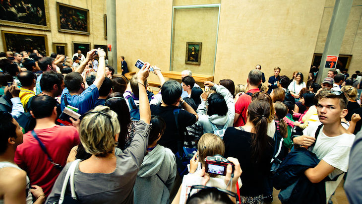 Crowds taking photos of the Mona Lisa in the Louvre. Photo: Wikimedia commons