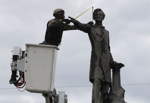A New Orleans city worker wears body armour and a face covering as he measures the Jefferson Davis monument on 4 May, 2017, in New Orleans, Loiusiana. Photo: Justin Sullivan/Getty Images