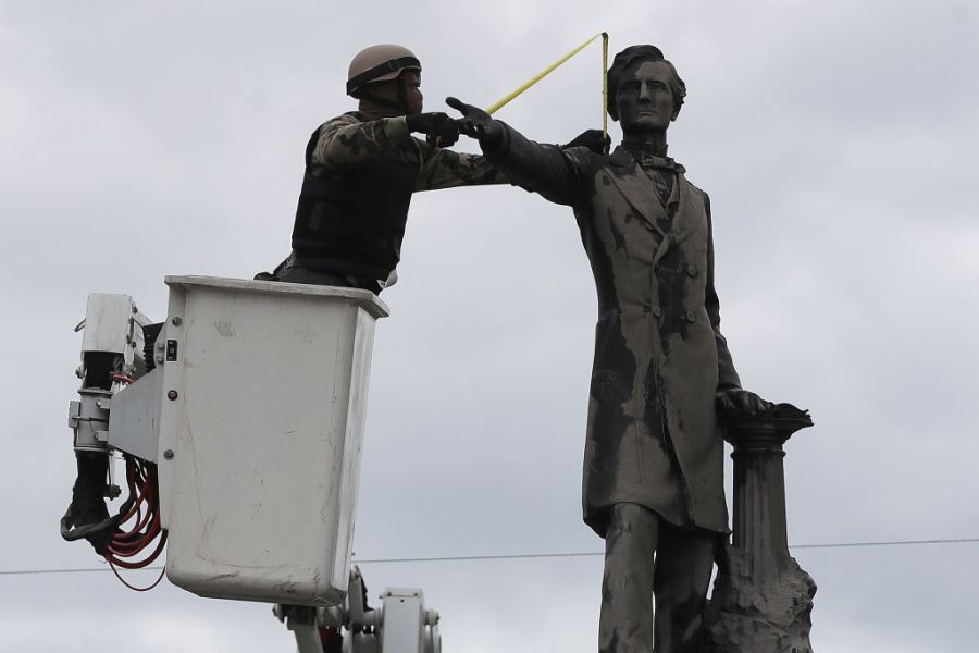 A New Orleans city worker wears body armour and a face covering as he measures the Jefferson Davis monument on 4 May, 2017, in New Orleans, Loiusiana. Photo: Justin Sullivan/Getty Images