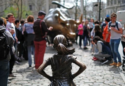 The Fearless Girl (front) statue stands facing the 'Charging Bull' as tourists take pictures in New York on 12 April, 2017. JEWEL SAMAD/AFP/Getty Images