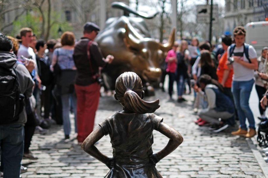 The Fearless Girl (front) statue stands facing the 'Charging Bull' as tourists take pictures in New York on 12 April, 2017. JEWEL SAMAD/AFP/Getty Images