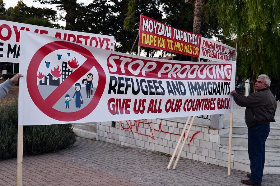 Chios residents arrange banners during an anti-migrant demo on the island of Chios on 28 September, 2016. Irish photographer Richard Mosse claims he was arrested while observing a similar rally on the island last week. Photo: LOUISA GOULIAMAKI/AFP/Getty Images