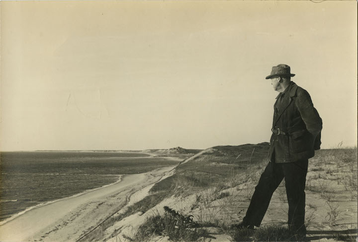 Portrait of Edward Hopper in the sand dunes of Cape Cod, c. 1930-1940. The Sanborn Hopper Archive at the Whitney Museum of American Art