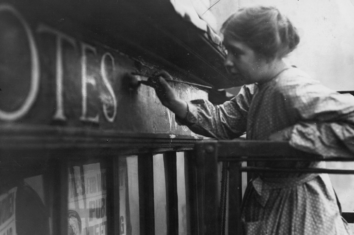 Sylvia Pankhurst painting onto the façade of the Women's Social Defence League shop in Bow Street, London (11 October 1912).