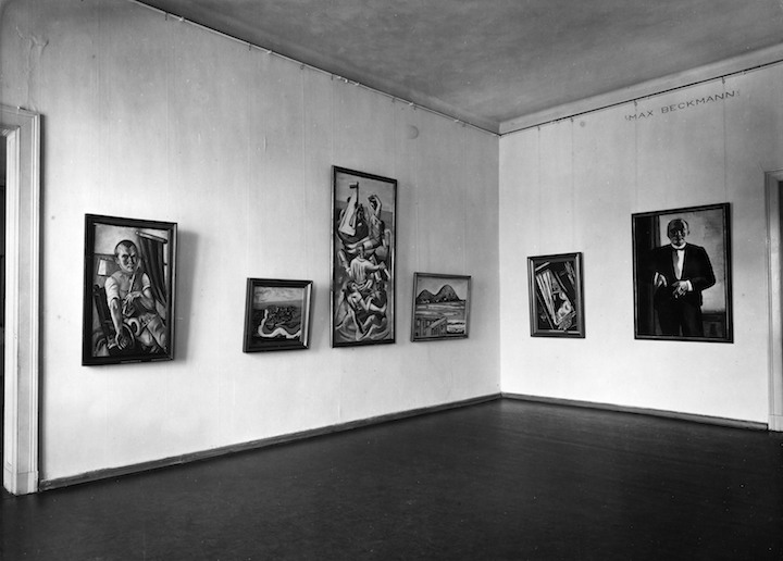 Self-Portrait in Tuxedo (1927) by Max Beckmann (far right), photographed in the Nationalgalerie in 1932–33). © Staatliche Museen zu Berlin, Zentralarchiv; VG Bild-Kunst, Bonn, 2018