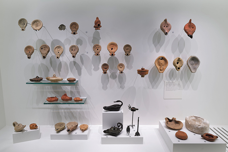 A display of decorated oil lamps – used for both everyday lighting and ritual practices – in terracotta and bronze, Roman era