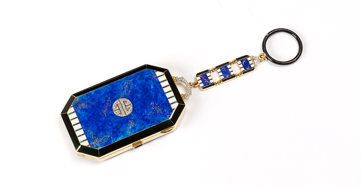 Gold vanity case decorated with blue, black and white enamel and diamonds, with a suspension chain with finger ring (1923–25), Lacloche, Paris.