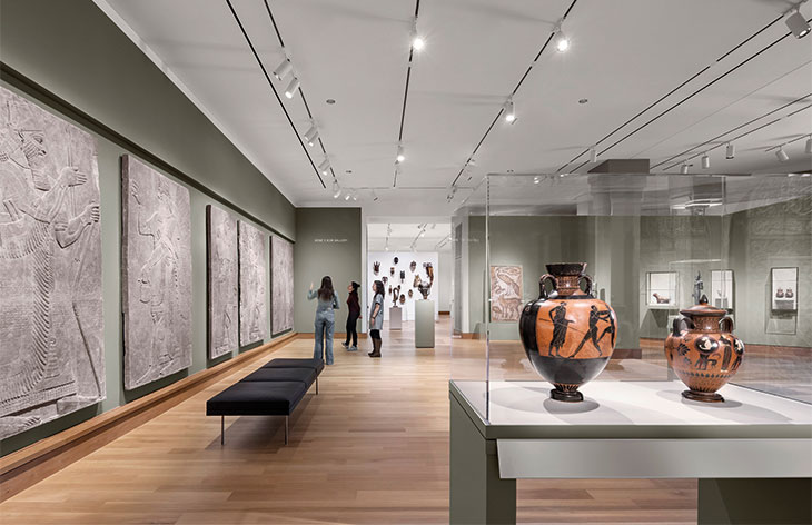 Ancient art in the newly renovated Kim Gallery includes, along the left-hand wall, reliefs from the north-west palace of Ashurnasirpal II at Nimrud, 883–859 BC. A display of traditional African art is visible in the Albright Gallery beyond.