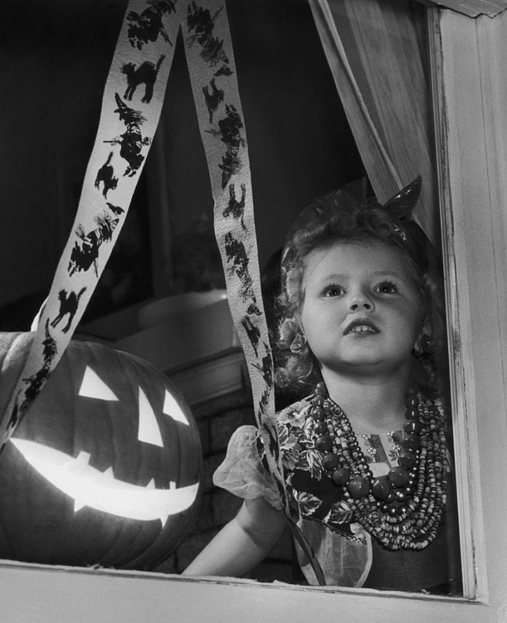 A girl waiting for guests to arrive at her Halloween party, USA (c. 1955), Joe Clark.