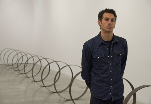 Rayyane Tabet in front of Steel Rings (2013–), from the series The Shortest Distance Between Two Points (2007–).