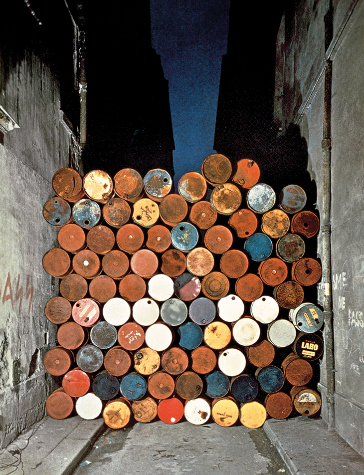 Installation view of Wall of Oil Barrels – The Iron Curtain in the Rue Visconti, Paris (1961–62), Christo and Jeanne-Claude.