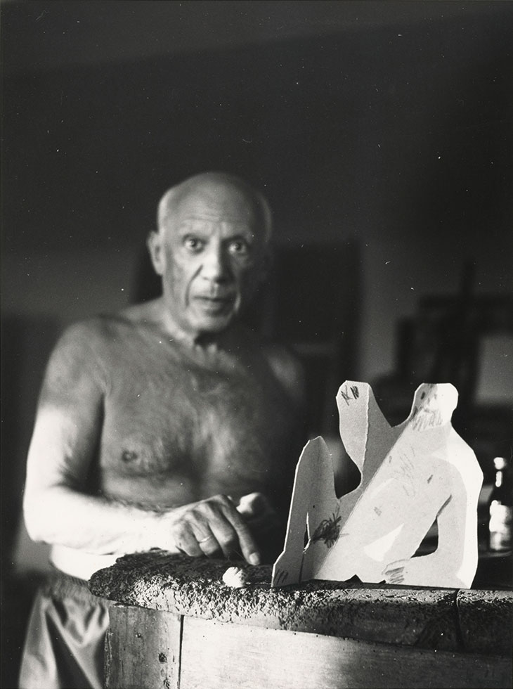 Picasso with a cardboard sculpture of a seated man for Le Déjeuner sur l’herbe, photographed in August 1962.