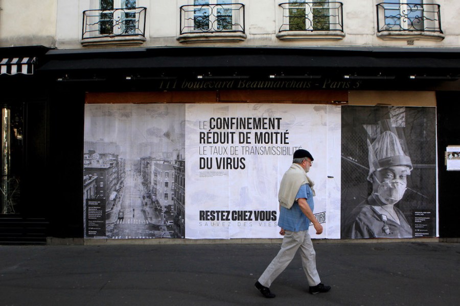 Pasted photographs by Gaia Squarci (Prospekt), and Ashely Gilbertson (VII) on Boulevard des Filles du Calvaire, Paris, 2020.