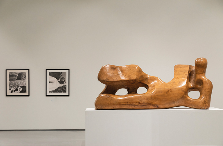 Installation view of Reclining Figure, 1936, Henry Moore (1898–1986) with prints from Perspective of Nudes (1961) by Bill Brandt at Hepworth Wakefield