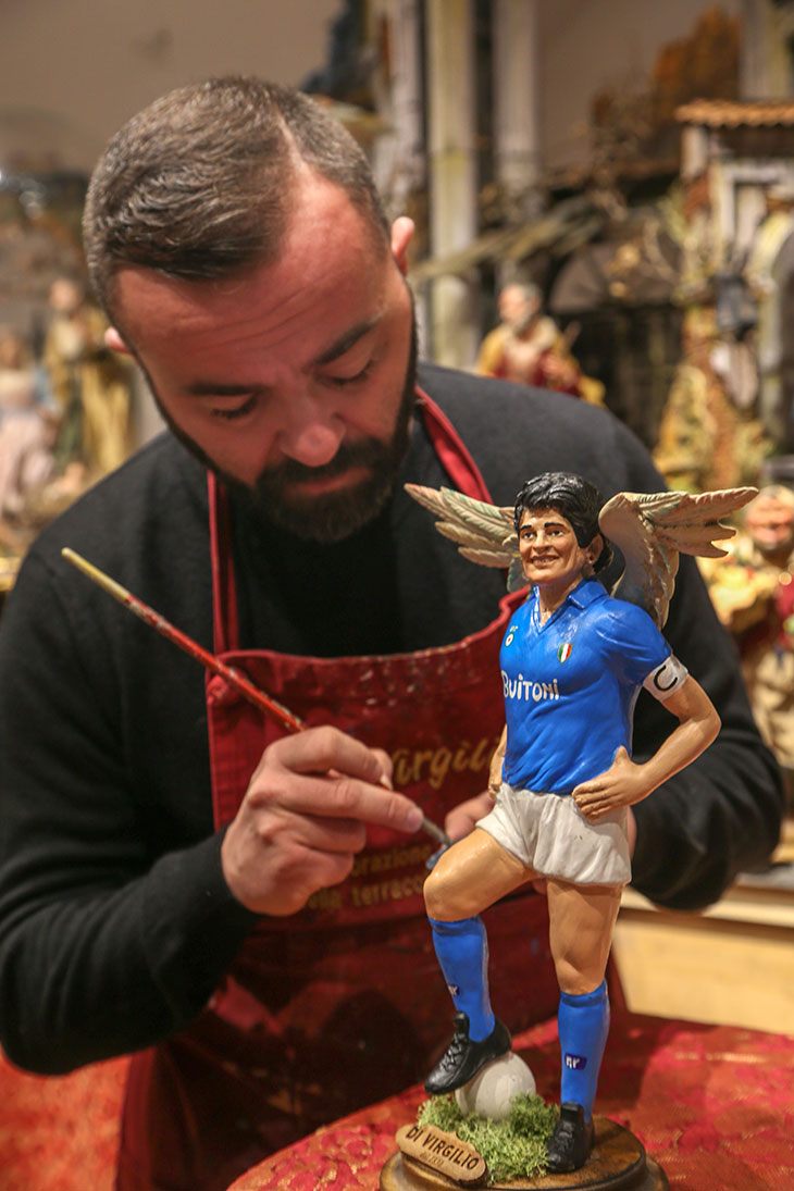 Gennaro Di Virgilio painting a statuette of Diego Maradona with wings on 26 November in Naples.