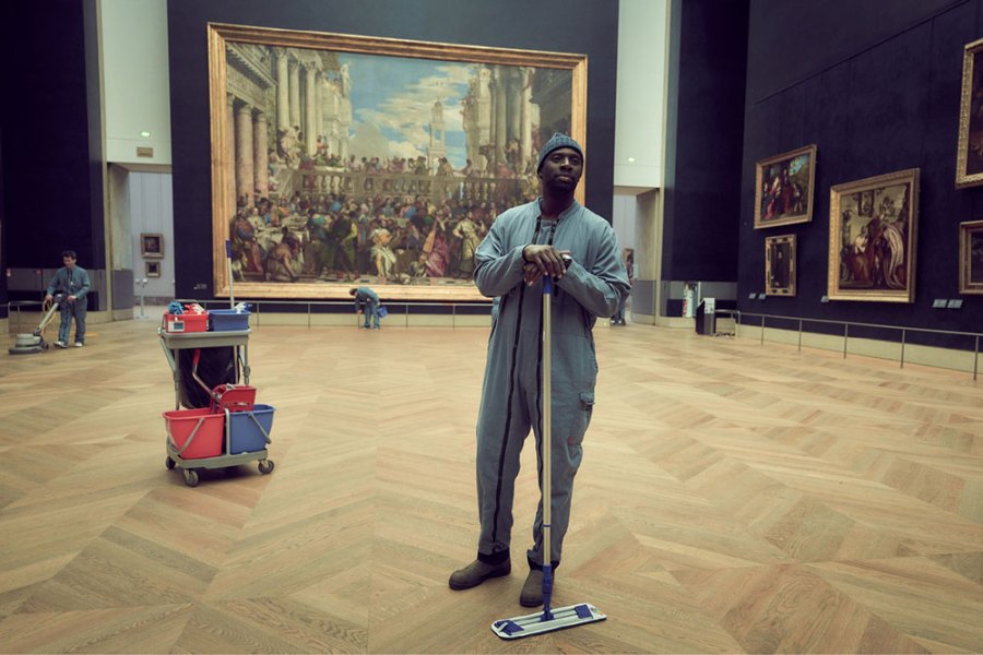 Omar Sy as Assane Diop in 'Lupin', with Veronese's 'Wedding Feast at Cana' in the background.