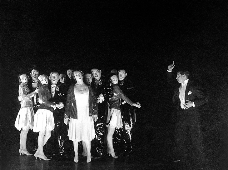 Sonnie Hale and chorus in ‘Dance, Little Lady’ (with masks designed by Oliver Messel) from This Year of Grace (1928), photographed by Lenare. 