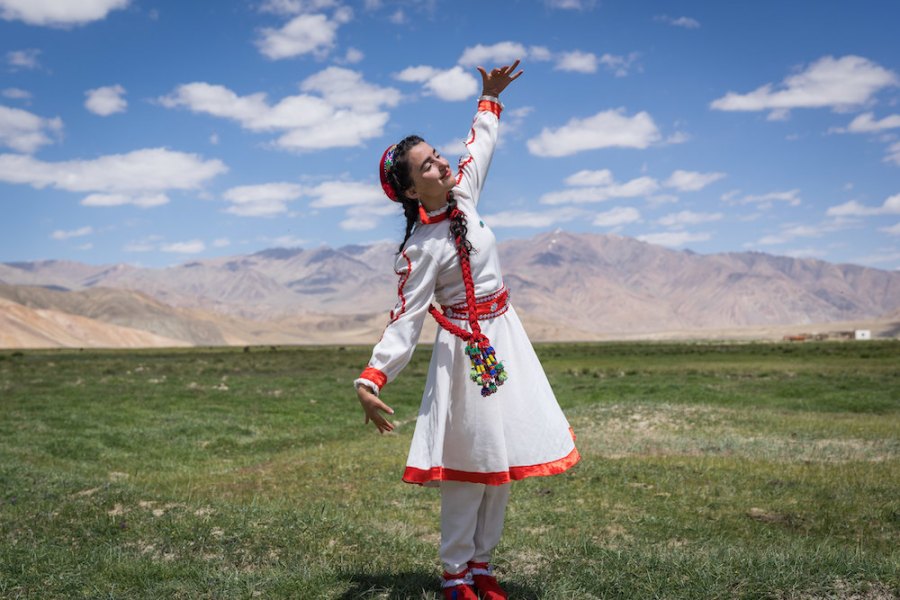 A girl in traditional Tajik dress dances at the opening of a new tourism centre in Bulunkul, Tajikistan (2019), Christopher Wilton-Steer.