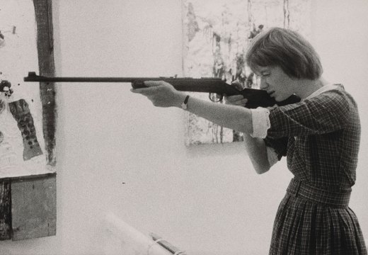 Niki de Saint-Phalle taking aim at her Feu à Volonté at Galerie J in Paris, in 1961.