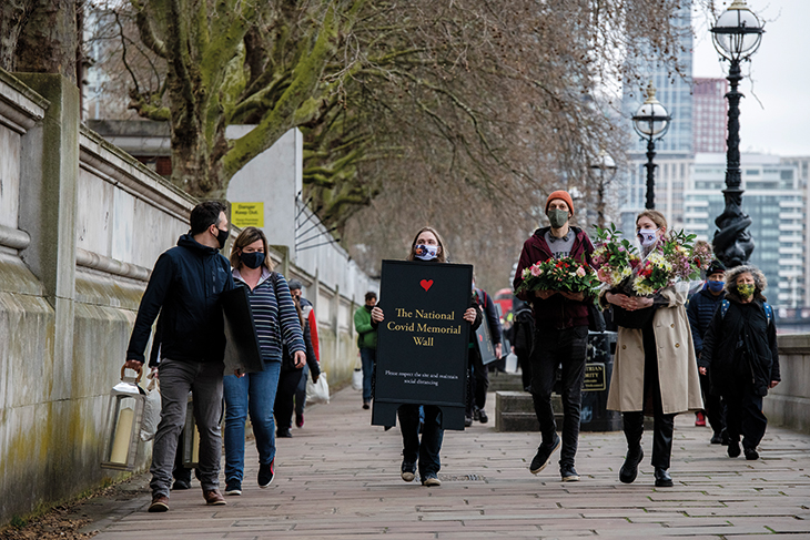 Oliver Knowles of Led By Donkeys and Matt Fowler of Covid-19 Bereaved Families for Justice among those carrying materials to set up the Covid memorial wall in March 2021.