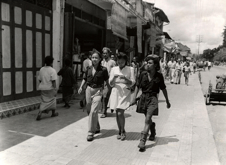 Three young Indonesians on a street. Two of them are Republican volunteers from Sulawesi, members of the armed youth organisation KRIS, on leave in Yogyakarta, December 1947, Hugo Wilmar.