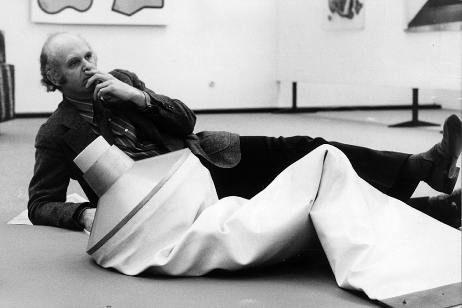 Pop artist Claes Oldenburg with one of his works, an outsize tube of toothpaste on display in the Dusseldorf Kunsthalle, West Germany.