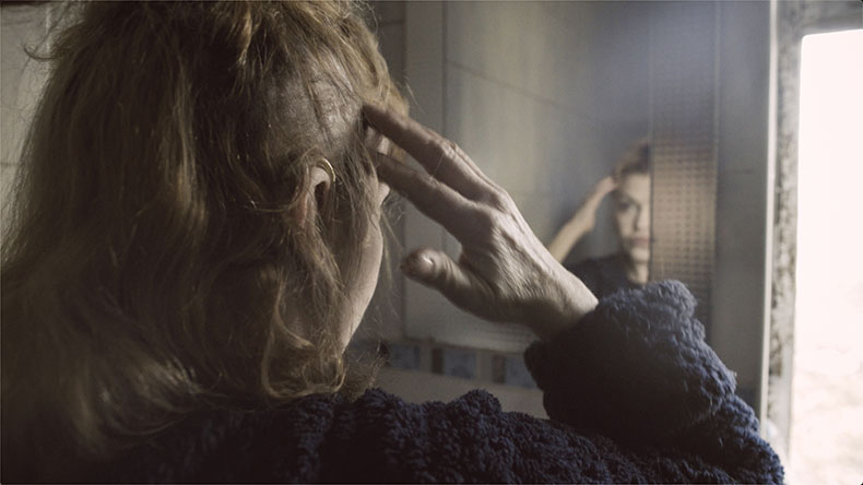 photograph of a woman looking in the mirror